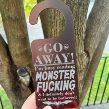 Load image into Gallery viewer, Go Away! I'm busy reading Monster Fucking... Door Hanger
