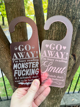 Load image into Gallery viewer, Go Away! I'm busy reading Smut... Door Hanger
